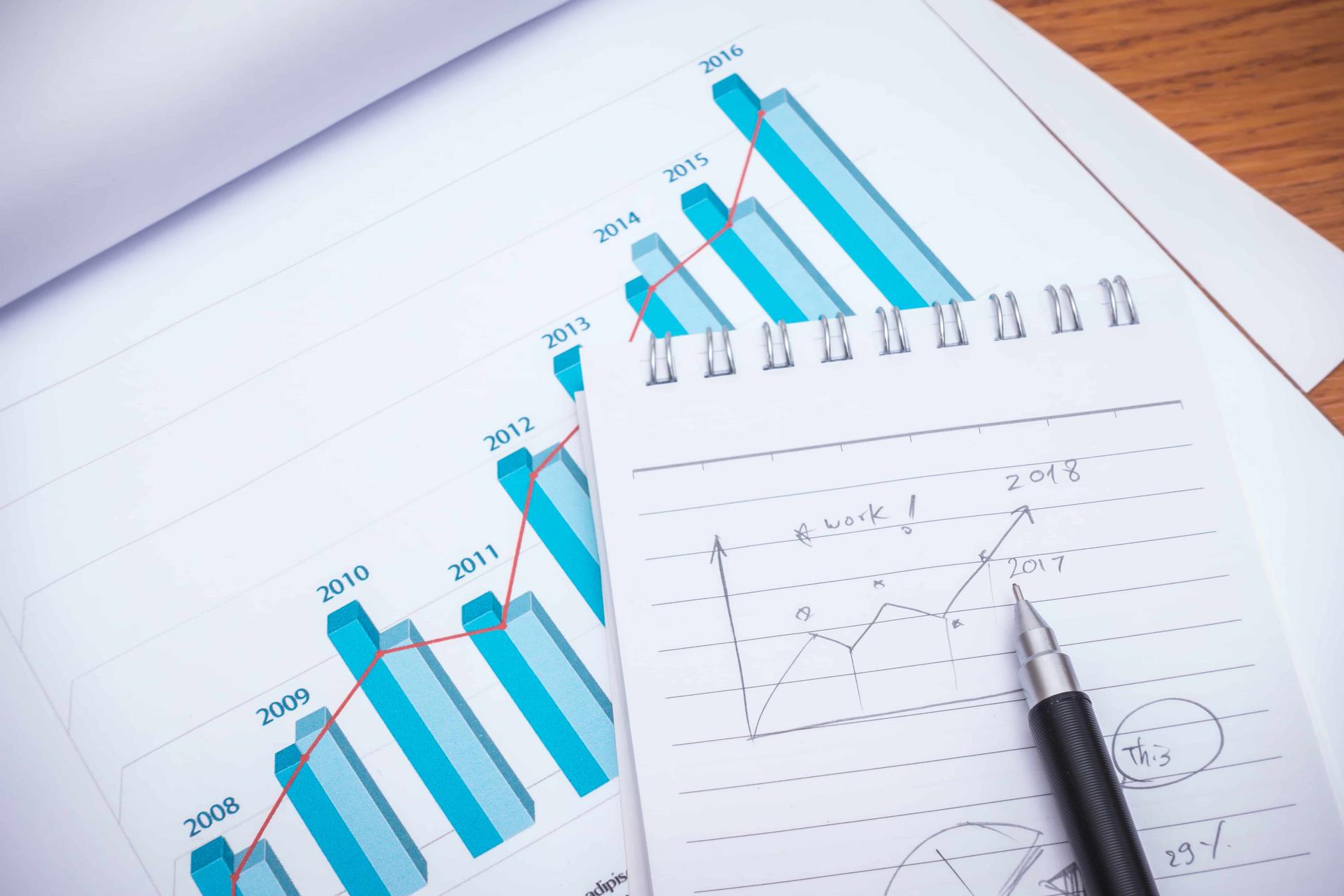 financial-charts-with-pencil-on-table-min
