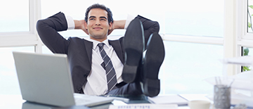 Smiling businessman relaxing in his office